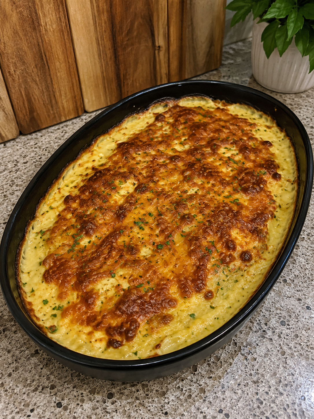 Individual air fryer potato gratin with golden melted cheddar in a small ramekin